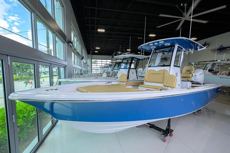 The Image of 2025 Sportsman Masters 267 Bay Boat in showroom, featuring sleek blue design and modern amenities. - 1