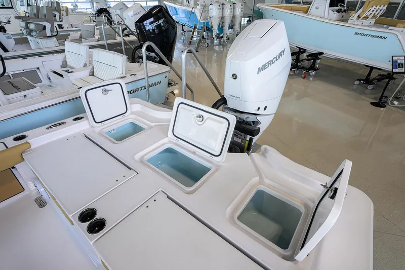 Slide: The Image of 2025 Sportsman Masters 267 Bay Boat with open storage compartments and Mercury engine. - 16