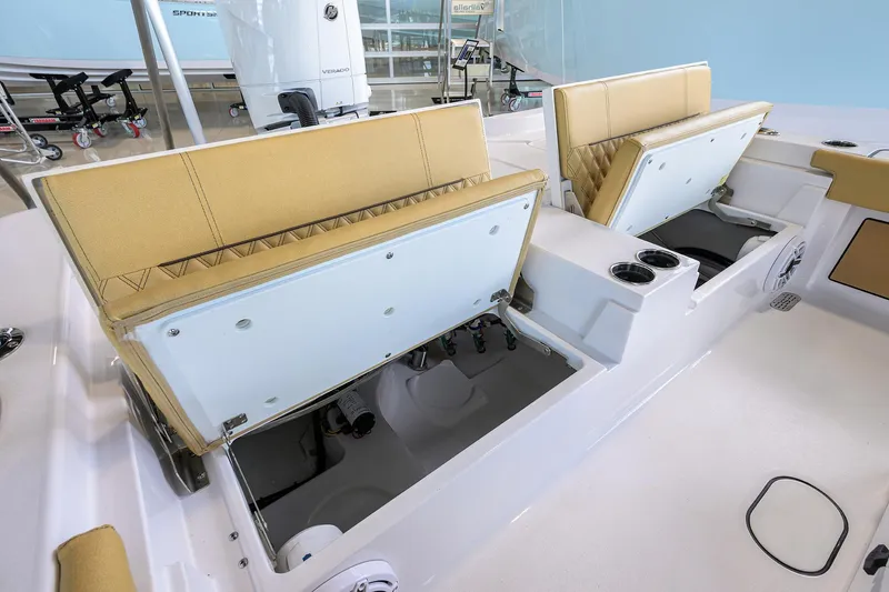 Slide: The Image of 2025 Sportsman Masters 267 Bay Boat interior with open storage compartments and tan seating. - 19