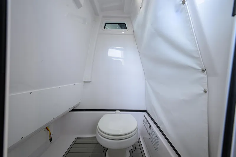 Slide: The Image of 2025 Sportsman Masters 267 Bay Boat interior with compact marine toilet. - 23