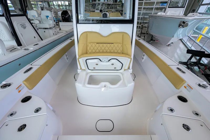 Slide: The Image of 2025 Sportsman Masters 267 Bay Boat interior with tan seating and storage compartments. - 24