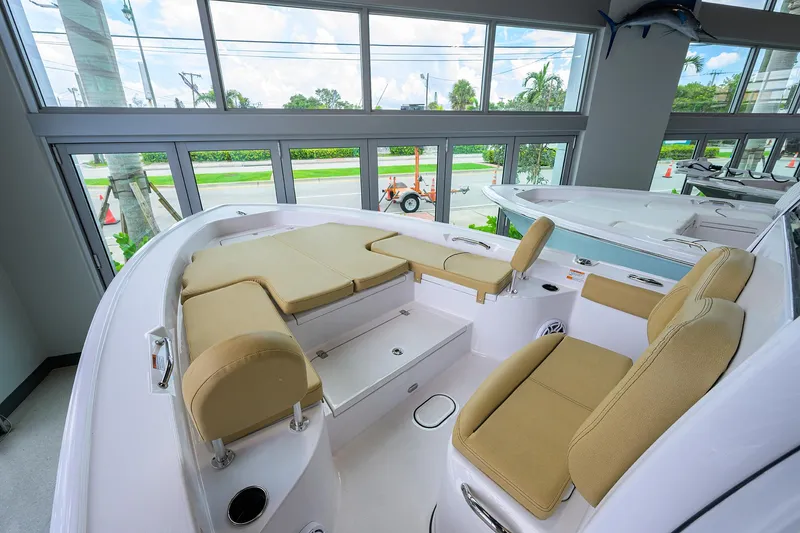 Slide: The Image of 2025 Sportsman Masters 267 Bay Boat interior with beige seating, showcased in a bright showroom. - 25