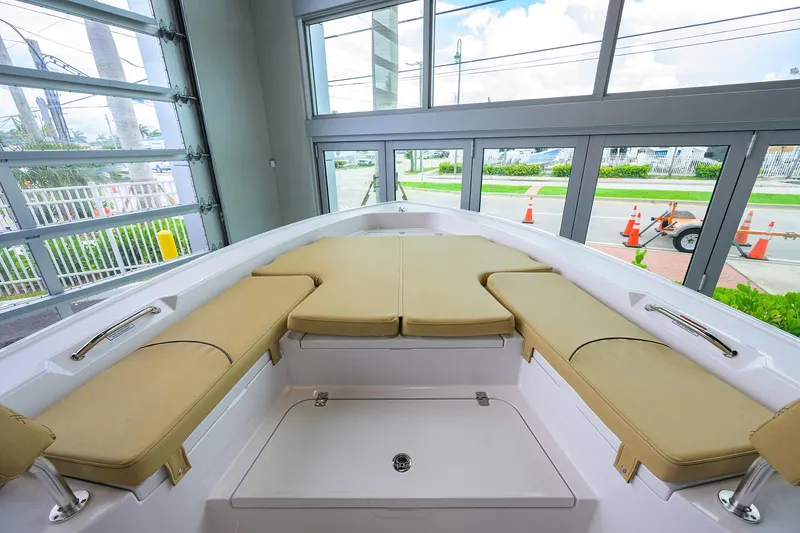 Slide: The Image of 2025 Sportsman Masters 267 Bay Boat interior with beige seating, docked indoors. - 26