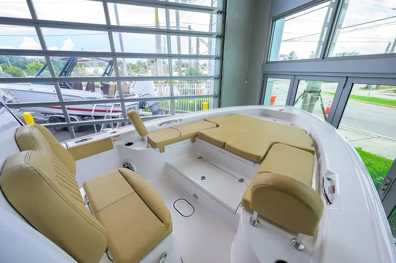 Slide: The Image of 2025 Sportsman Masters 267 Bay Boat interior with beige seating, displayed in a showroom. - 27