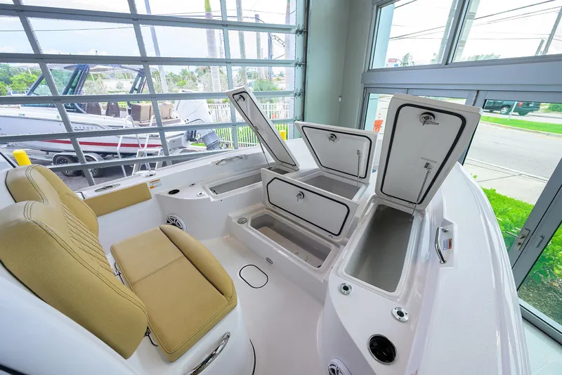 Slide: The Image of 2025 Sportsman Masters 267 Bay Boat interior with open storage compartments and beige seating. - 31