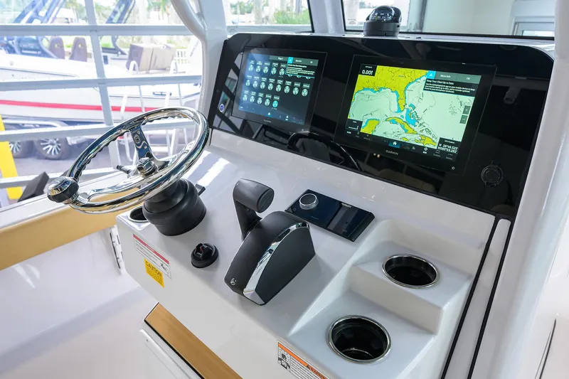 Slide: The Image of 2025 Sportsman Masters 267 Bay Boat dashboard with steering wheel and navigation screens. - 7