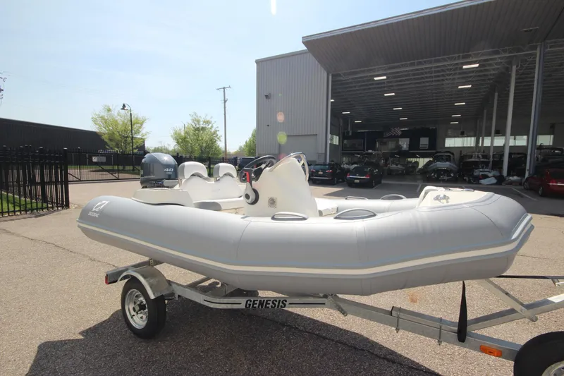Slide: The Image of 2025 Zodiac Yachtline 360 DL PVC boat on trailer, parked outside dealership. - 2