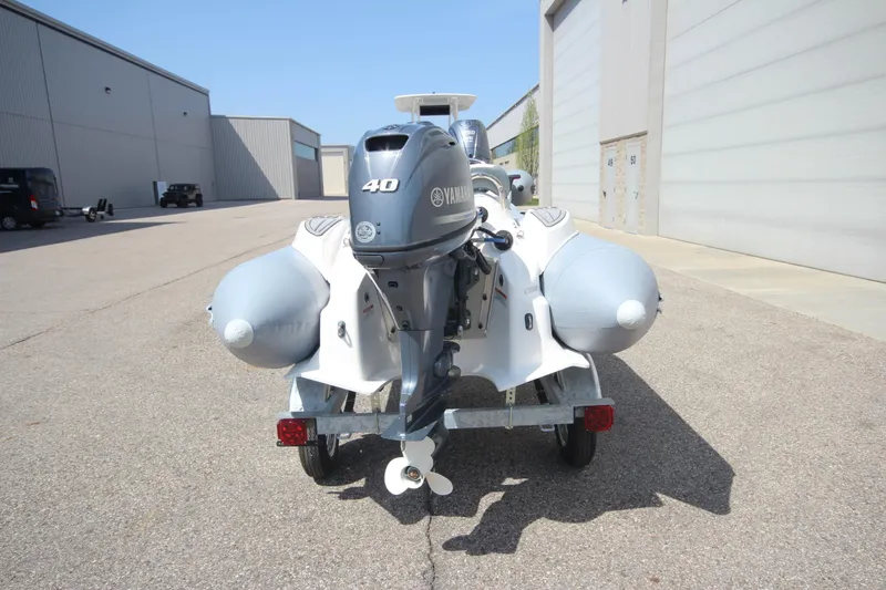 Slide: The Image of 2025 Zodiac Yachtline 360 DL PVC with 40hp engine on trailer, parked outdoors. - 3