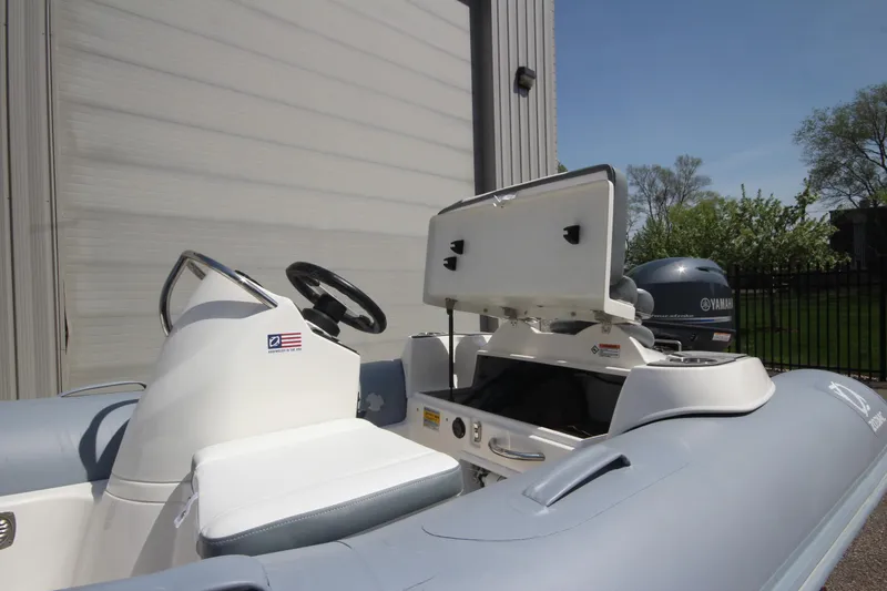 Slide: The Image of 2025 Zodiac Yachtline 360 DL PVC boat with 40hp engine, docked outdoors. - 5