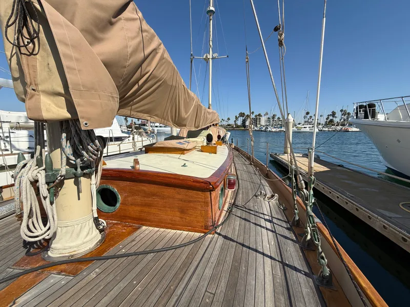 Slide: The Image of Historic 1932 Fellows & Stewart Yawl with wooden deck, docked in a sunny marina. - 10