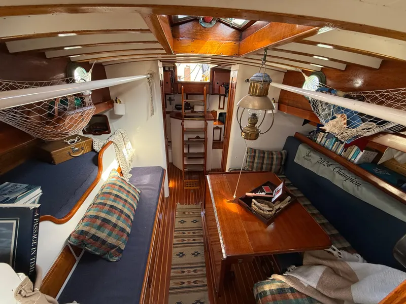 Slide: The Image of Interior of a 1932 Historic Fellows & Stewart Yawl, featuring cozy seating and nautical decor. - 21