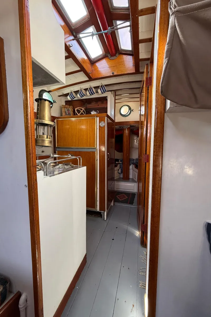Slide: The Image of Interior of 1932 Fellows & Stewart Yawl, featuring wooden cabinetry and skylights. - 23