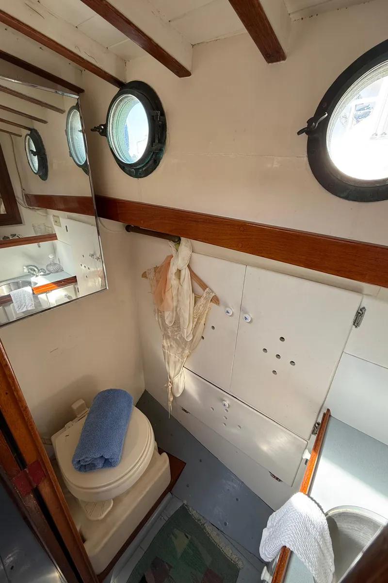 Slide: The Image of Interior of 1932 Fellows & Stewart Yawl with portholes, toilet, and wooden accents. - 26