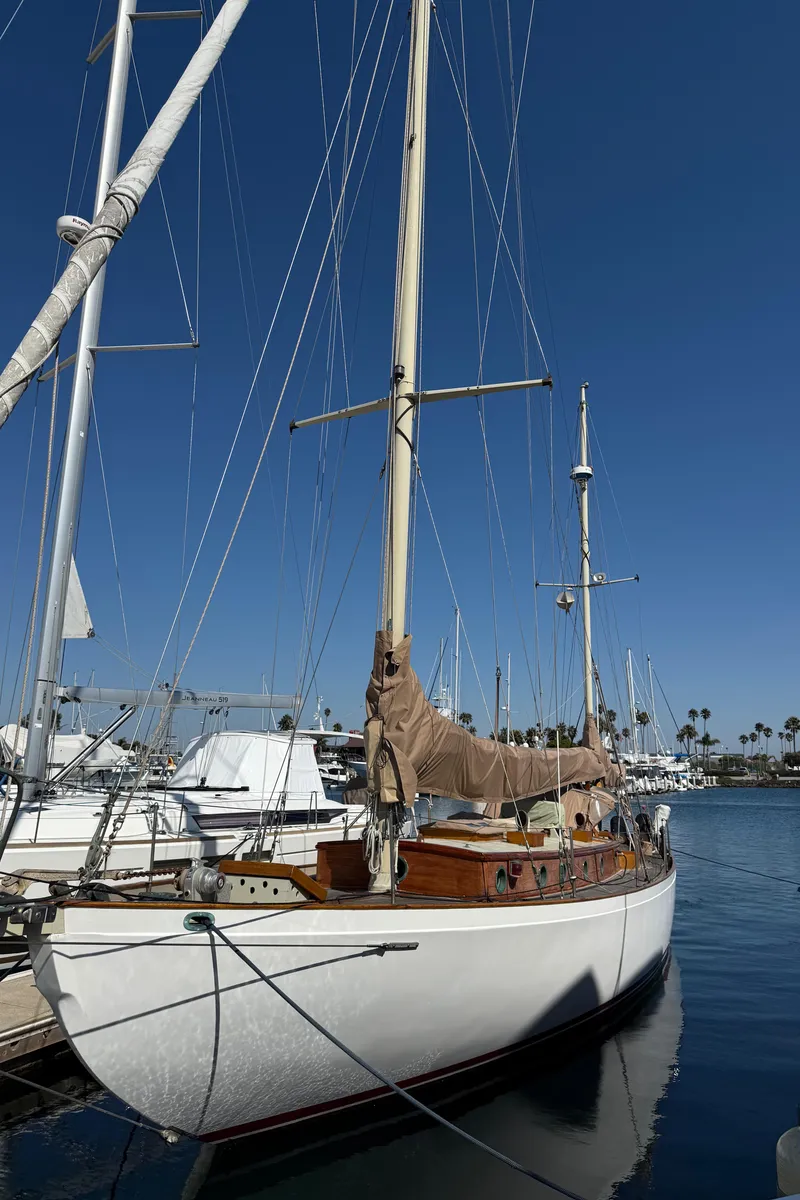 Slide: The Image of Historic 1932 Fellows & Stewart Yawl docked at marina under clear blue sky. - 4