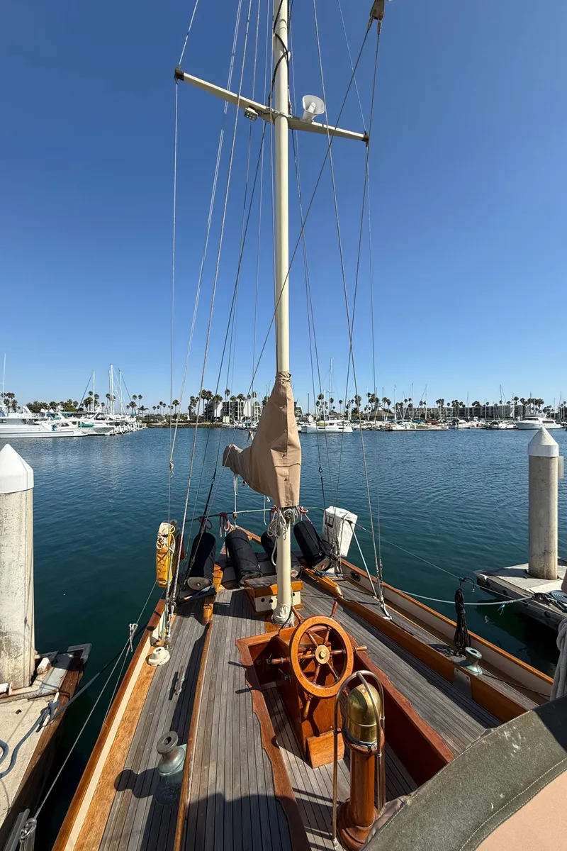 Slide: The Image of Historic 1932 Fellows & Stewart Yawl docked at a marina under clear blue skies. - 8