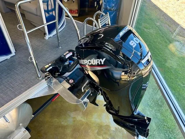 Slide: The Image of 2025 Barletta A22QC with Mercury outboard motor, displayed indoors. - 13