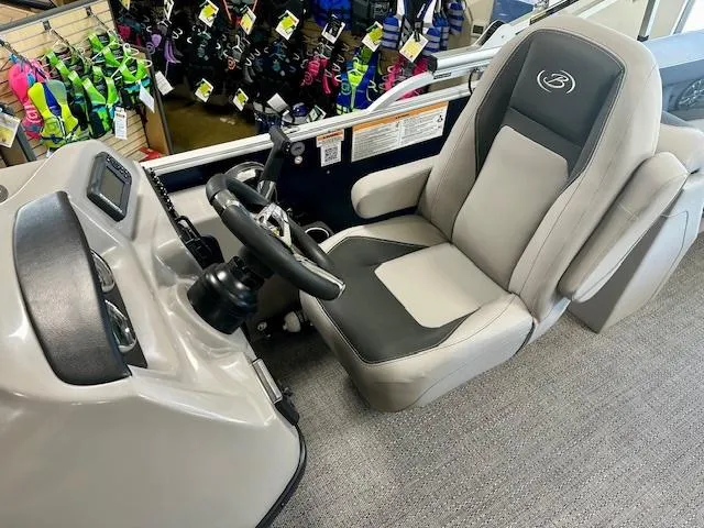 Slide: The Image of Captain's seat of 2025 Barletta A22QC boat, featuring modern steering and controls. - 5