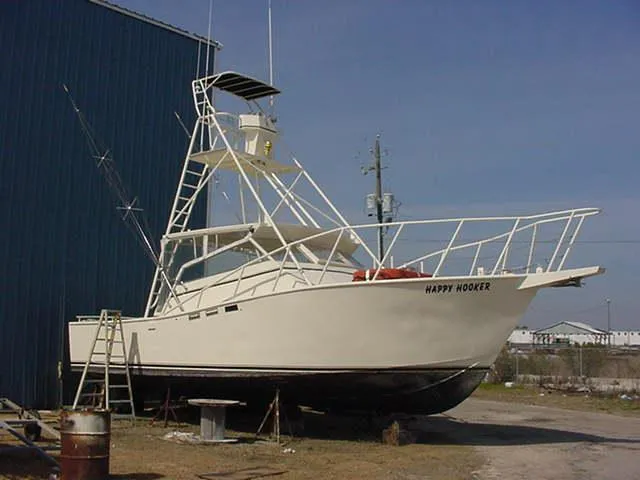 Slide: The Image of 1988 Custom Universal Ship Building Sport fishing boat on land, named "Happy Hooker." - 16