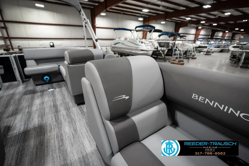 Slide: The Image of 2025 Bennington 118 SLS pontoon boat interior with gray seating in a showroom. - 20
