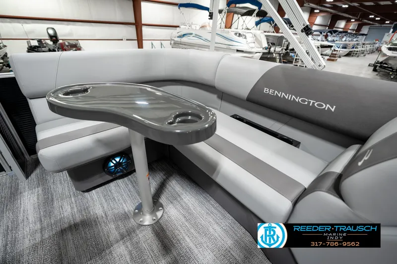 Slide: The Image of 2025 Bennington 118 SLS boat interior with gray seating and table in showroom. - 26