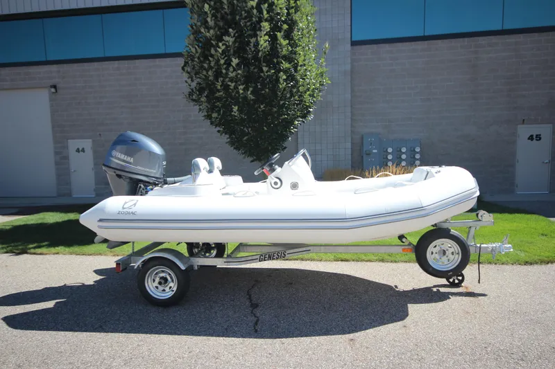 Slide: The Image of 2025 Zodiac Yachtline 400 DL NEO 50hp boat on trailer, parked outdoors. - 0