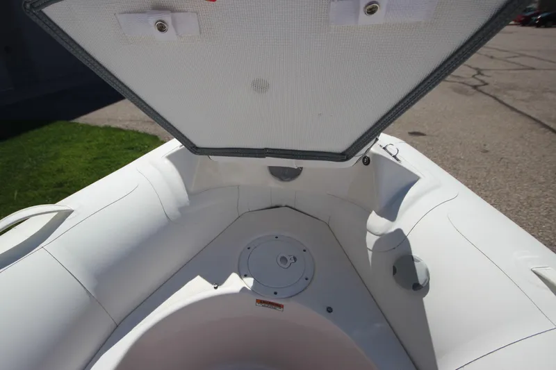 Slide: The Image of 2025 Zodiac Yachtline 400 DL NEO, open storage compartment, white interior, outdoor setting. - 13
