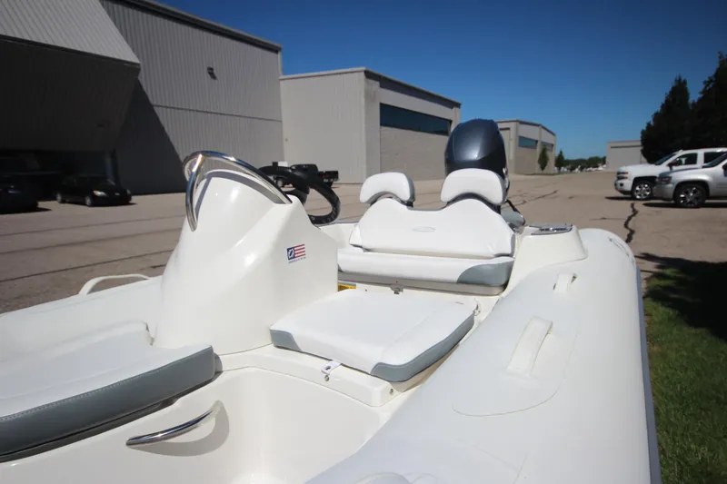Slide: The Image of 2025 Zodiac Yachtline 400 DL NEO 50hp boat, white interior, parked outdoors. - 2