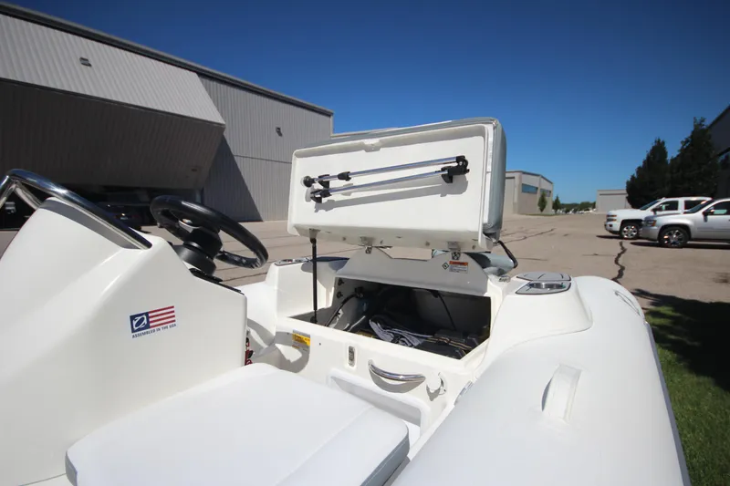 Slide: The Image of 2025 Zodiac Yachtline 400 DL NEO 50hp boat with open storage compartment, outdoor setting. - 6