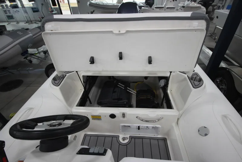 Slide: The Image of 2025 Zodiac Yachtline 490 Deluxe NEO 90hp boat interior with open storage compartment. - 10