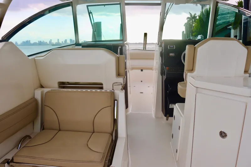Slide: The Image of Interior of 2017 Pursuit DC 295 Dual Console boat with beige seating and ocean view. - 11
