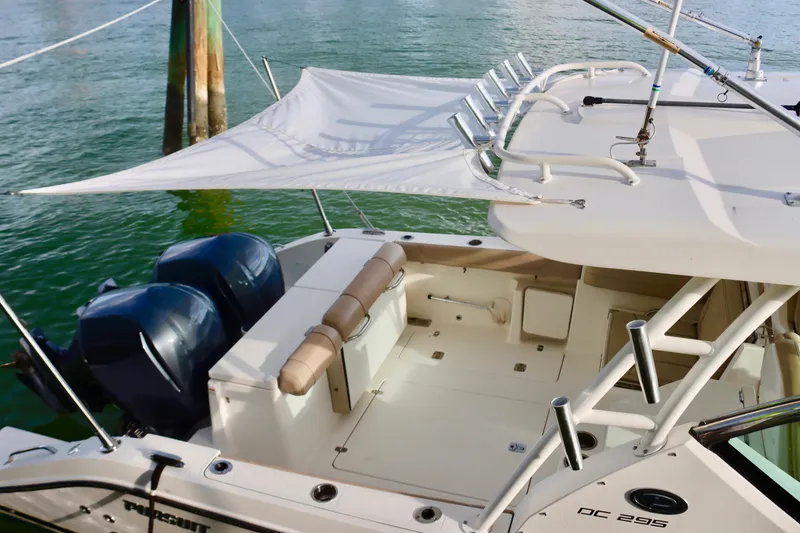 Slide: The Image of 2017 Pursuit DC 295 Dual Console boat with twin engines and sunshade on water. - 12
