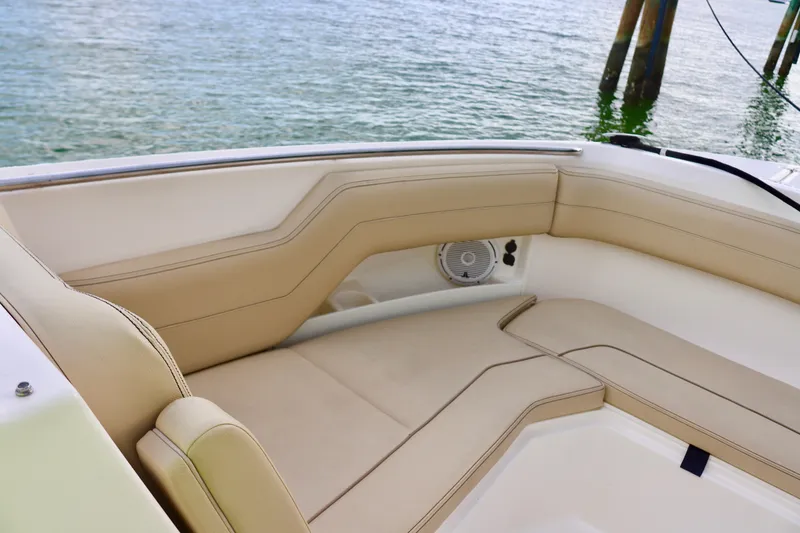 Slide: The Image of 2017 Pursuit DC 295 Dual Console boat interior with beige seating by the water. - 23