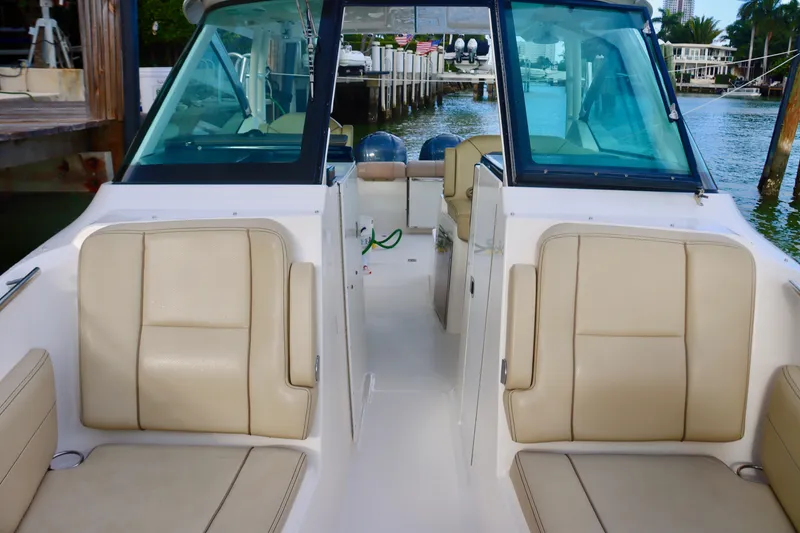 Slide: The Image of 2017 Pursuit DC 295 Dual Console boat interior with beige seating and waterfront view. - 25