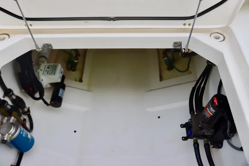Slide: The Image of 2017 Pursuit DC 295 Dual Console boat interior, showcasing storage and mechanical components. - 34