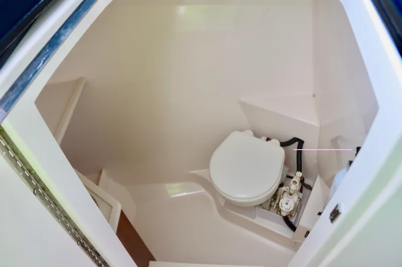 Slide: The Image of 2017 Pursuit DC 295 Dual Console boat interior with compact marine toilet. - 9