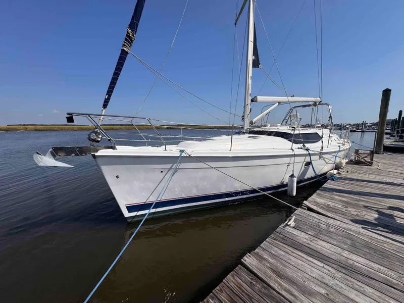 The Image of 2008 Hunter 45 Center Cockpit sailboat docked at a marina under clear blue skies. - 0