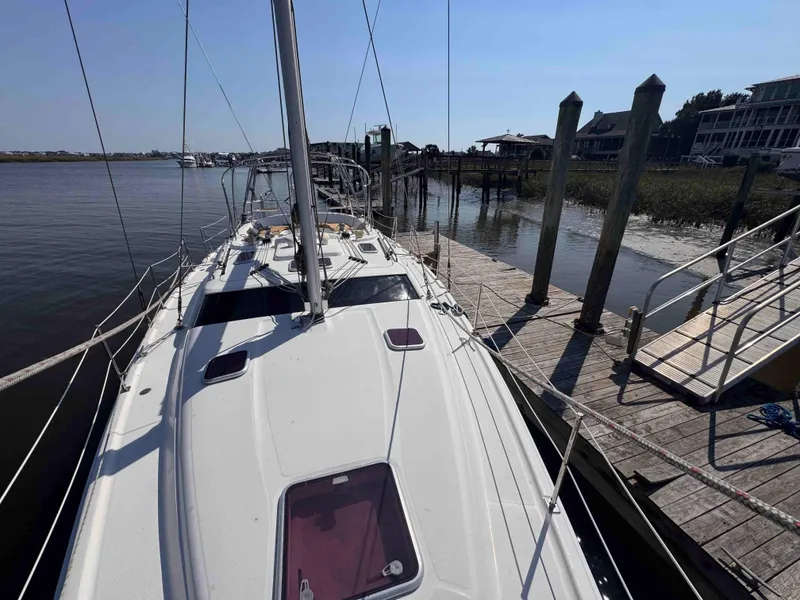 Slide: The Image of 2008 Hunter 45 Center Cockpit sailboat docked at a marina, viewed from the deck. - 11