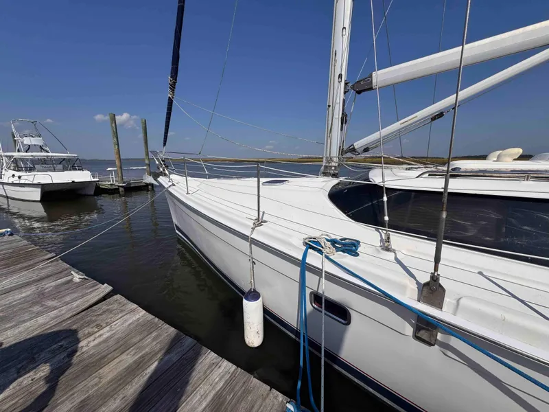 Slide: The Image of 2008 Hunter 45 Center Cockpit sailboat docked at marina under clear blue sky. - 2