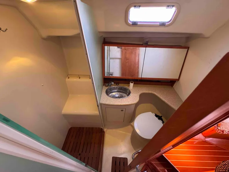 Slide: The Image of 2008 Hunter 45 Center Cockpit bathroom with sink, toilet, and mirror. - 21