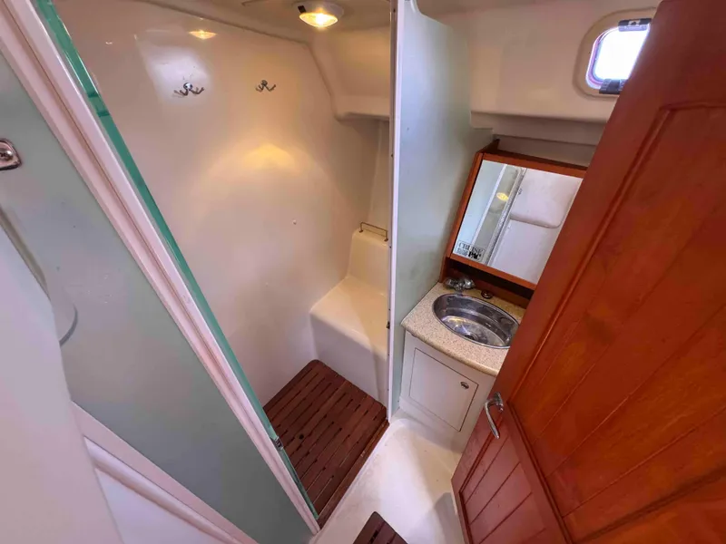 Slide: The Image of 2008 Hunter 45 Center Cockpit bathroom with shower, sink, and wooden accents. - 23