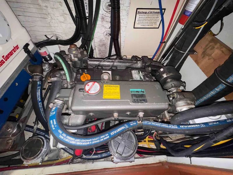Slide: The Image of Engine compartment of a 2008 Hunter 45 Center Cockpit sailboat, showing detailed components and hoses. - 26