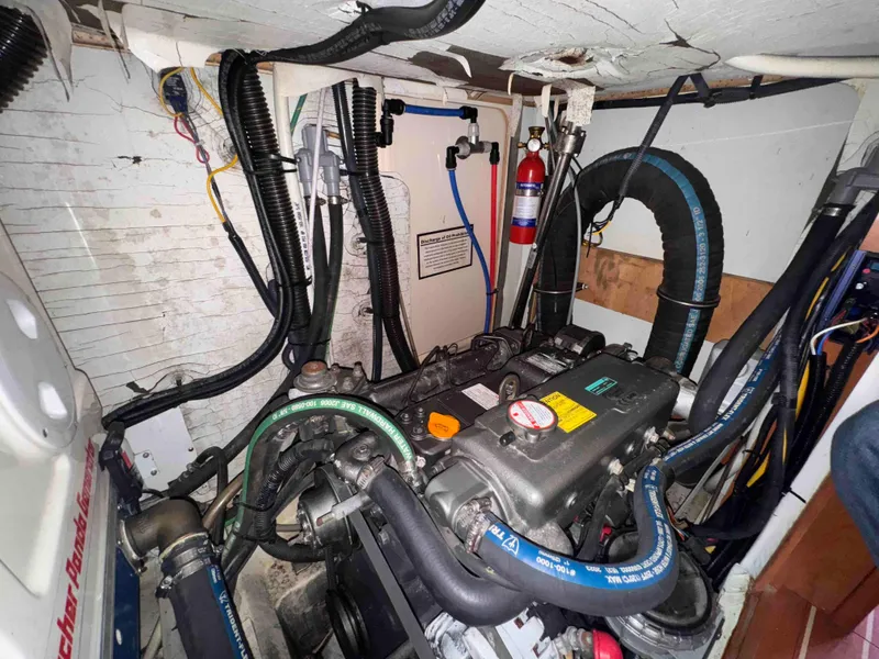 Slide: The Image of Engine compartment of a 2008 Hunter 45 Center Cockpit sailboat, showing various hoses and components. - 27