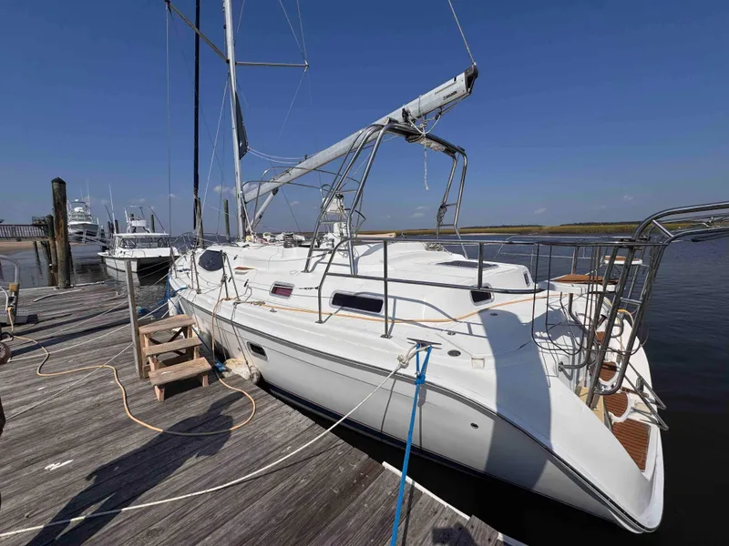 Slide: The Image of 2008 Hunter 45 Center Cockpit sailboat docked at a marina under clear blue skies. - 4