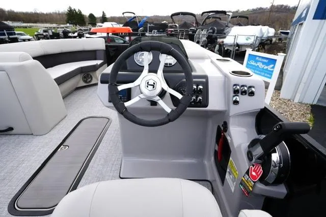 Slide: The Image of 2025 Harris 230 Cruiser boat interior with steering wheel and control panel. - 14