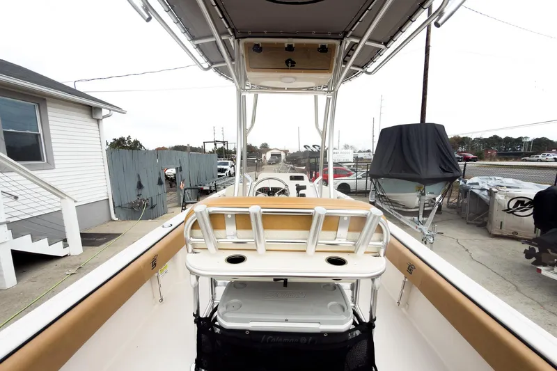 Slide: The Image of 2025 Carolina Skiff 21 Ultra Elite boat interior with seating and storage, docked outdoors. - 14