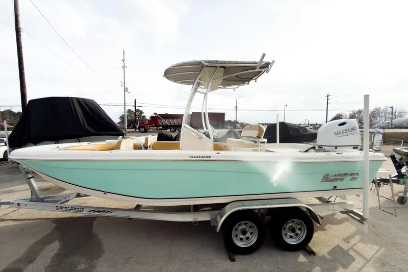 The Image of 2025 Carolina Skiff 21 Ultra Elite boat on trailer, featuring Suzuki outboard motor. - 2