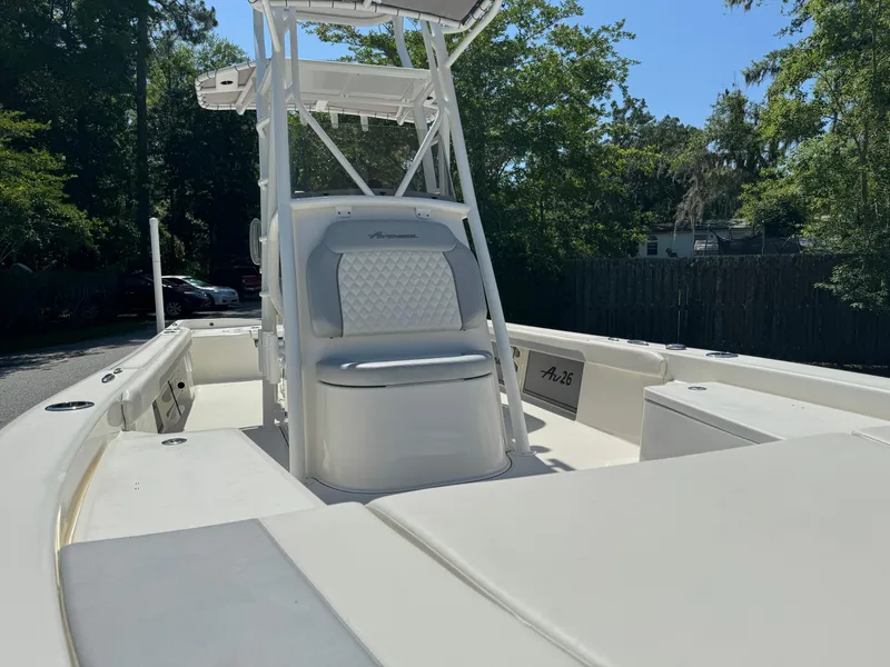 Slide: The Image of 2024 Avenger AV26 boat with white seating and console, surrounded by trees. - 12