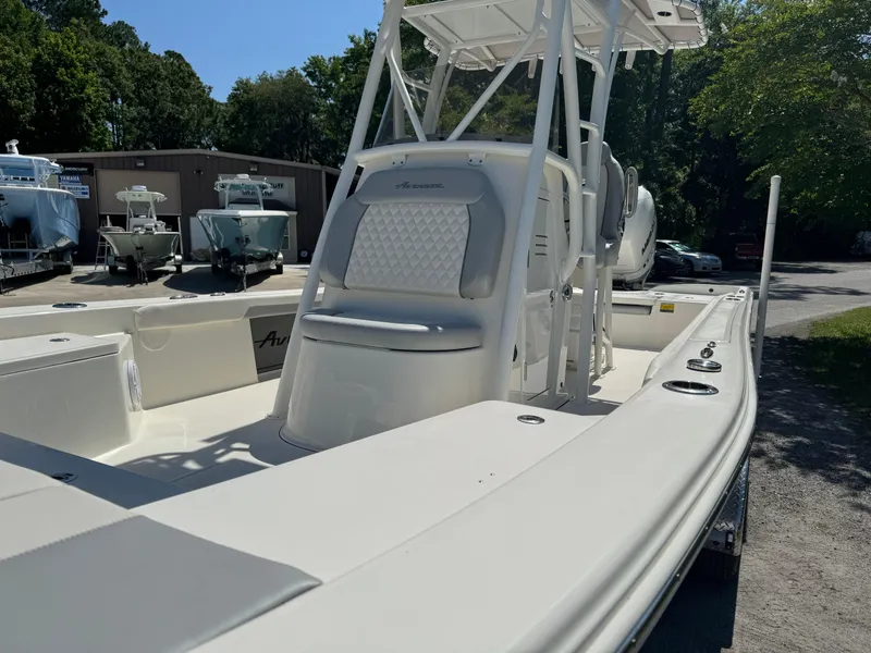 Slide: The Image of 2024 Avenger AV26 boat with sleek white design and spacious deck in a sunny outdoor setting. - 14