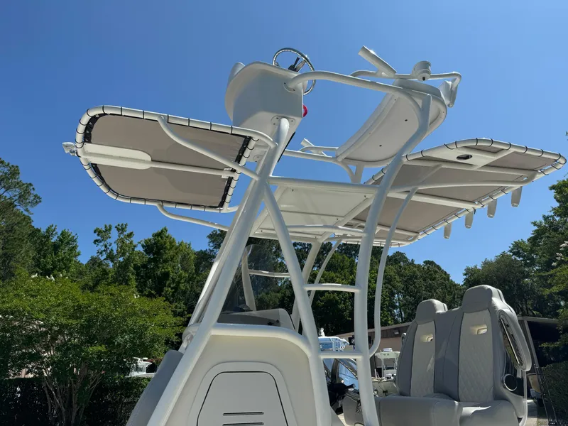 Slide: The Image of 2024 Avenger AV26 boat with T-top and seating, under clear blue sky. - 15