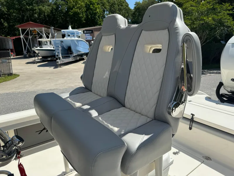 Slide: The Image of 2024 Avenger AV26 boat seats with quilted upholstery in a marina setting. - 20